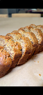 Loaf of banana bread sliced on a baking sheet